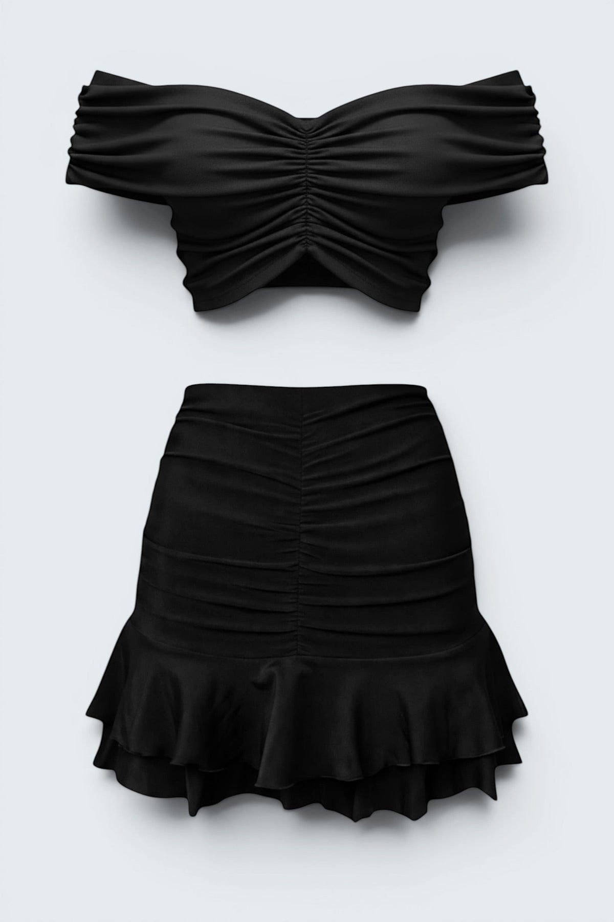 The Saint 54 black two-piece set featuring a gathered off-shoulder cropped top and a ruffled mini skirt.