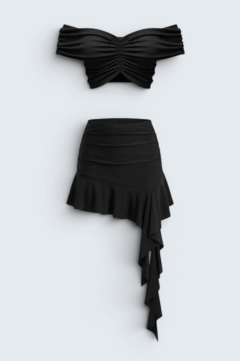 The Saint 54 black two-piece set with off-shoulder cropped top and asymmetrical ruffled mini skirt.