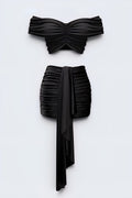 The Saint 54 black two-piece set with off-shoulder gathered crop top and high-waisted mini skirt with draped scarf