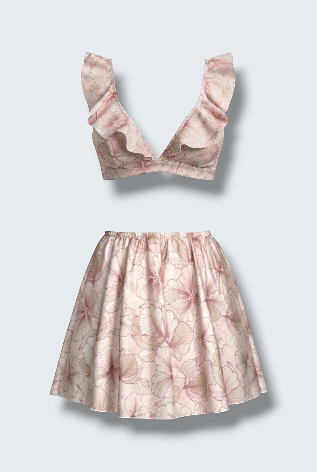 The Saint 54 pink floral two-piece set featuring a ruffled crop top and a high-waisted flared mini skirt.