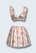 The Saint 54 pink floral two-piece set featuring a ruffled crop top and a high-waisted flared mini skirt.