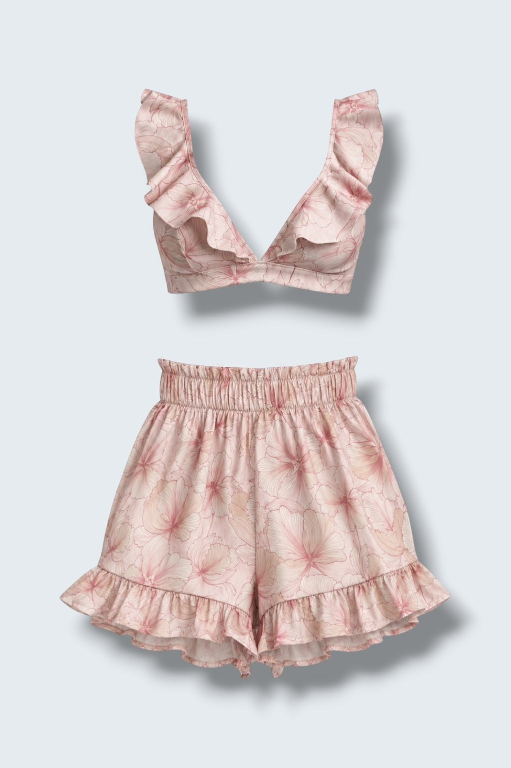 The Saint 54 pink floral two-piece set featuring a ruffled bralette top and high-waisted ruffled mini shorts.