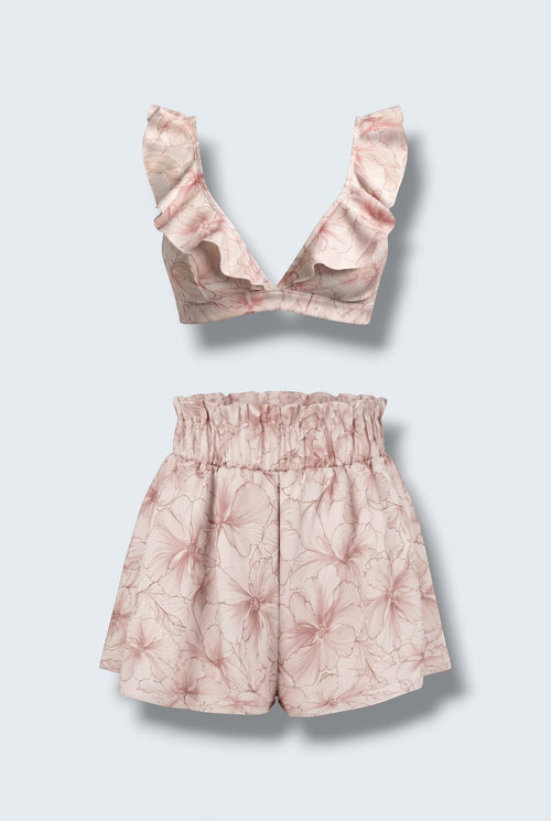 The Saint 54 pink floral two-piece set featuring a ruffled bralette top and high-waisted flared mini shorts.