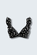The Saint 54 black bikini top with white polka dots, featuring statement ruffle details and picot edge finish.
