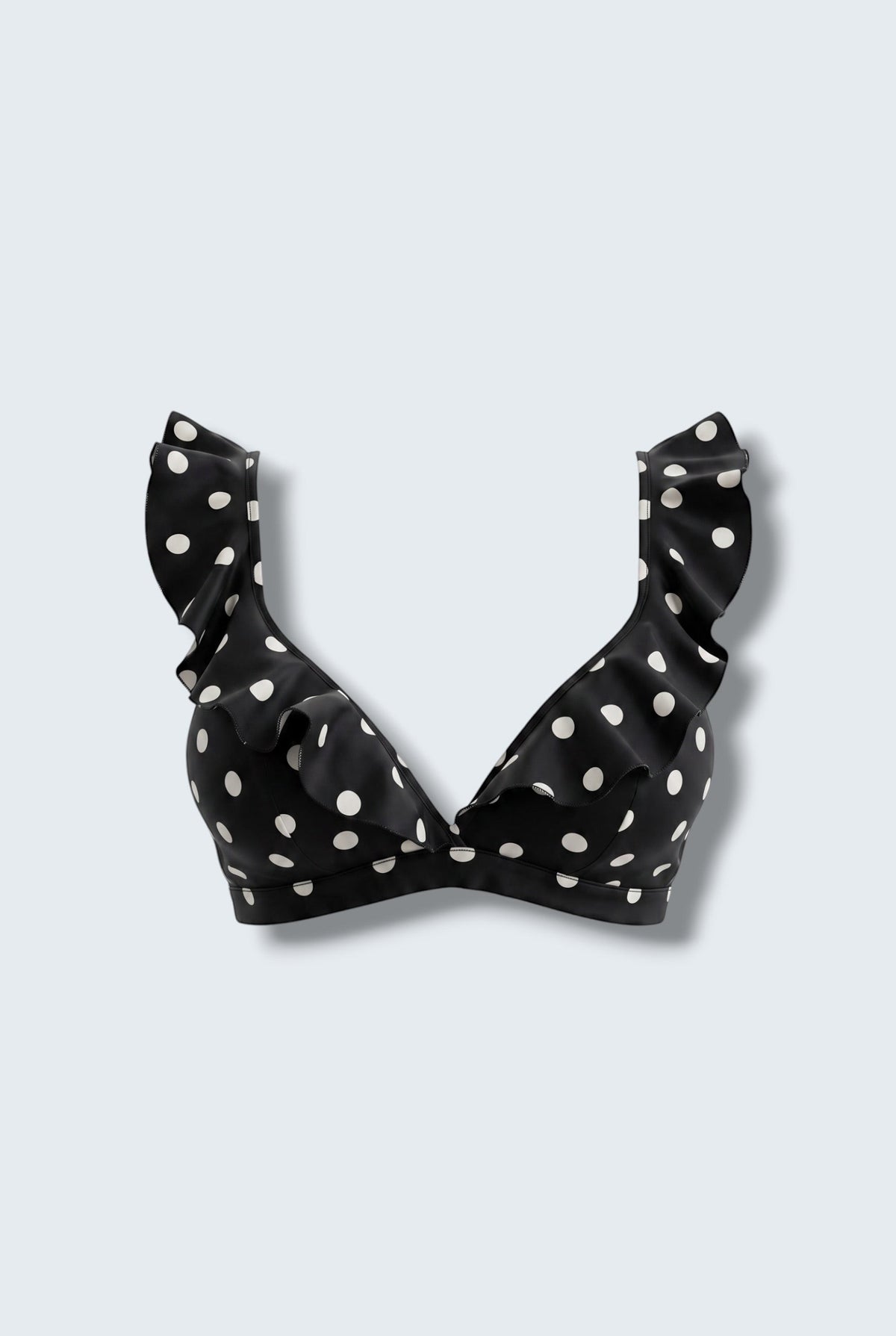 The Saint 54 black bikini top with white polka dots, featuring statement ruffle details and picot edge finish.