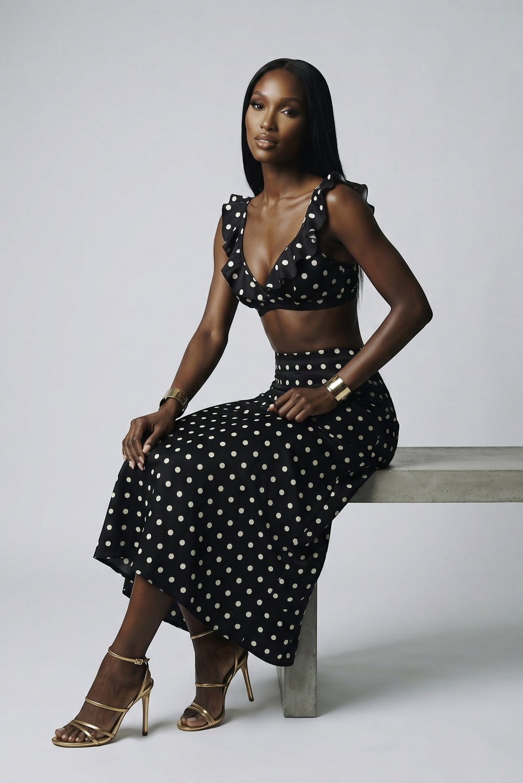 Model wearing The Saint 54 black and white polka dot crop top with statement ruffles and matching midi skirt