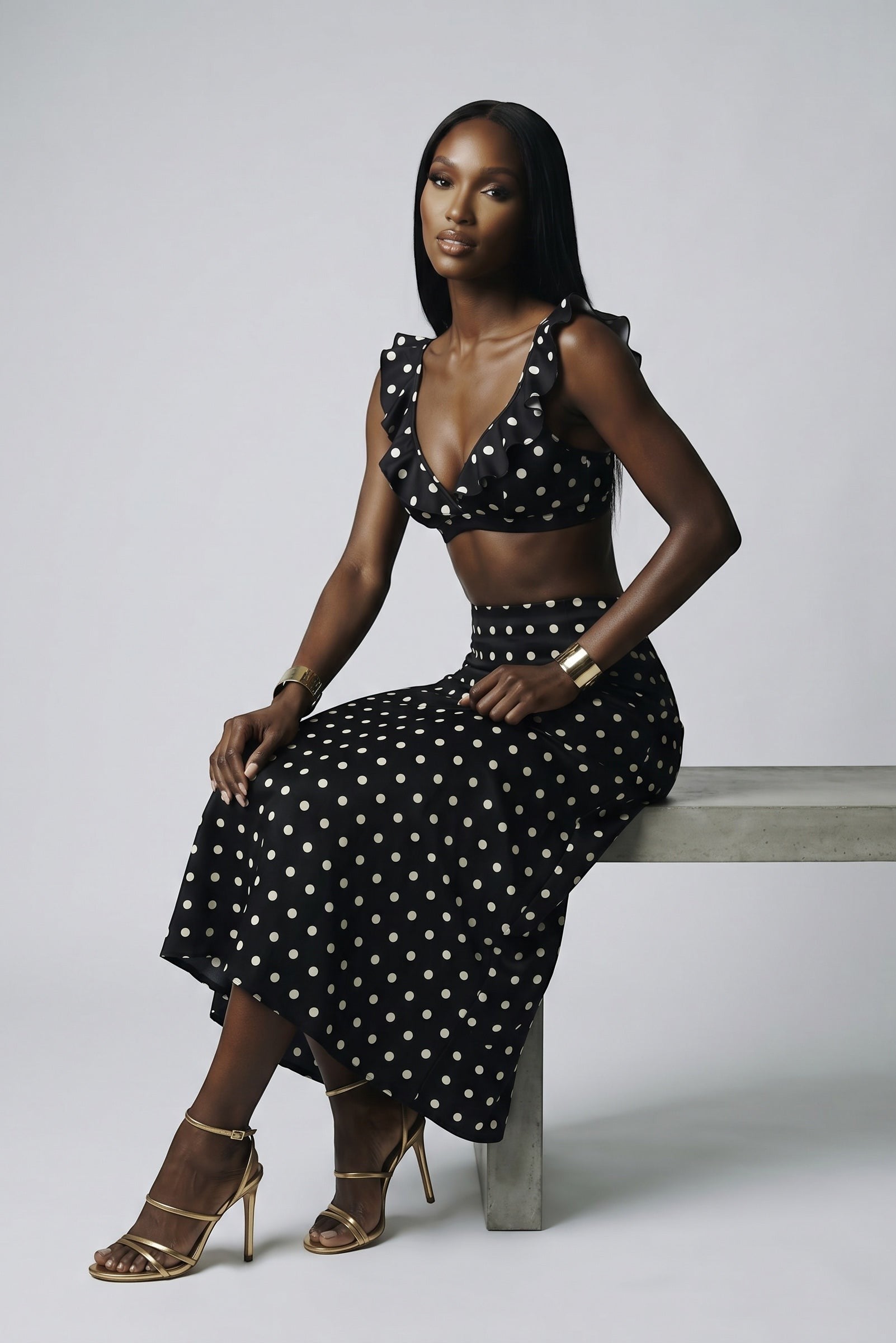 Model wearing The Saint 54 black and white polka dot crop top with statement ruffles and matching midi skirt