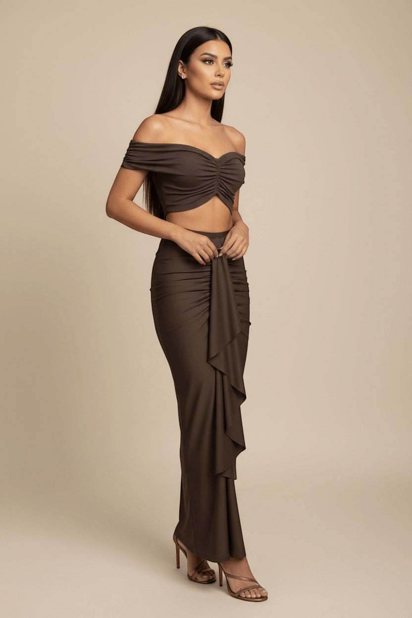The Saint 54 brown ruched off-shoulder crop top and maxi skirt set with draped scarf detail.